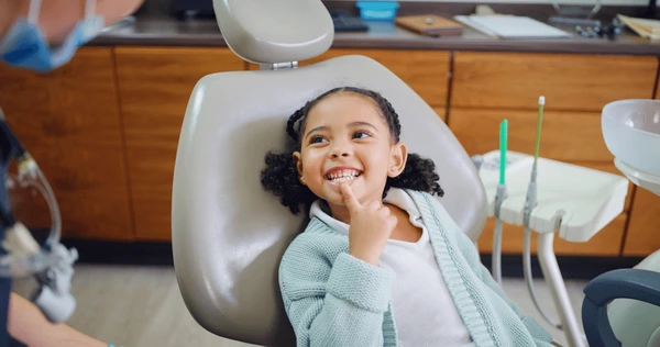 Dentiste enfant souriant en fauteuil