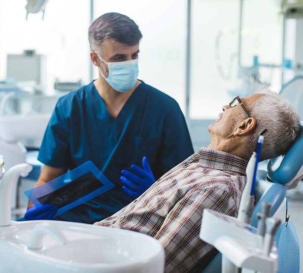 Dentiste en consultation avec un patient — montrer l'interrogatoire médical

