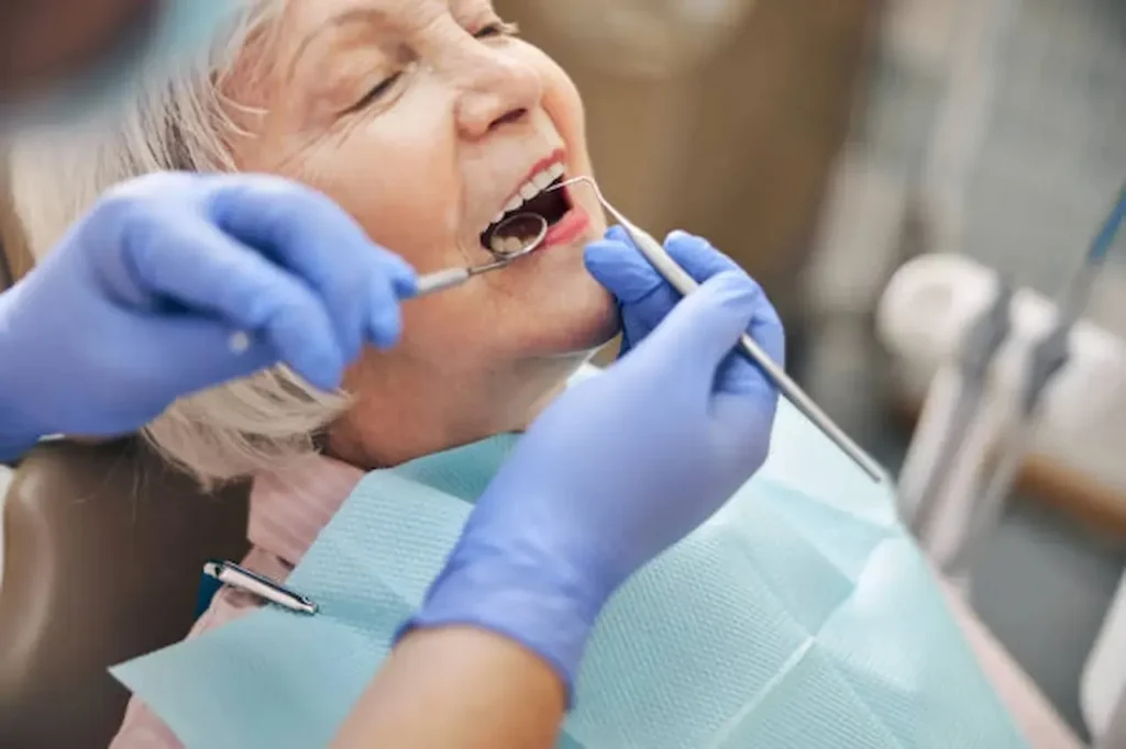 Dentiste examinant une molaire avec un miroir buccal
